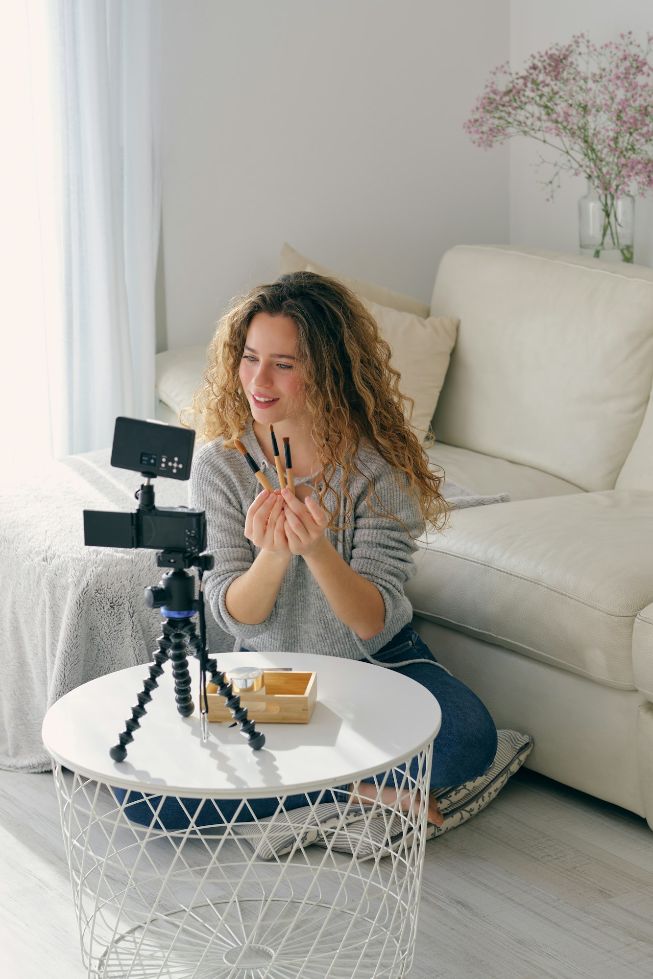 Woman live streaming and showing makeup brushes to followers